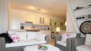 A modern living room with a sofa, two armchairs, a coffee table, and a dining area in the background. - Eckhorst Farm, Ruhwinkel (Güby)