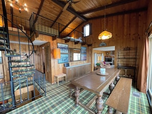 A wooden interior with a staircase, a dining area, and a fireplace. - The Cuyuna "Retro Retreat" Family Lake Home (Brainerd)