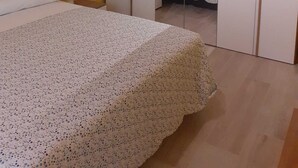 Un dormitorio con cama, armario y espejo.
