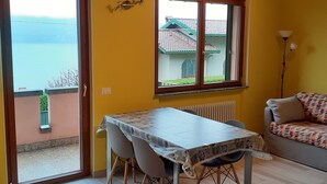 Un comedor con una mesa, sillas, una ventana con vistas, un sofá y una lámpara.