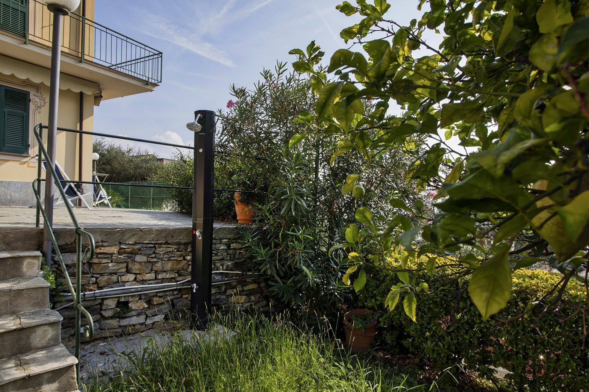 A stone staircase leading to a balcony with a metal railing.