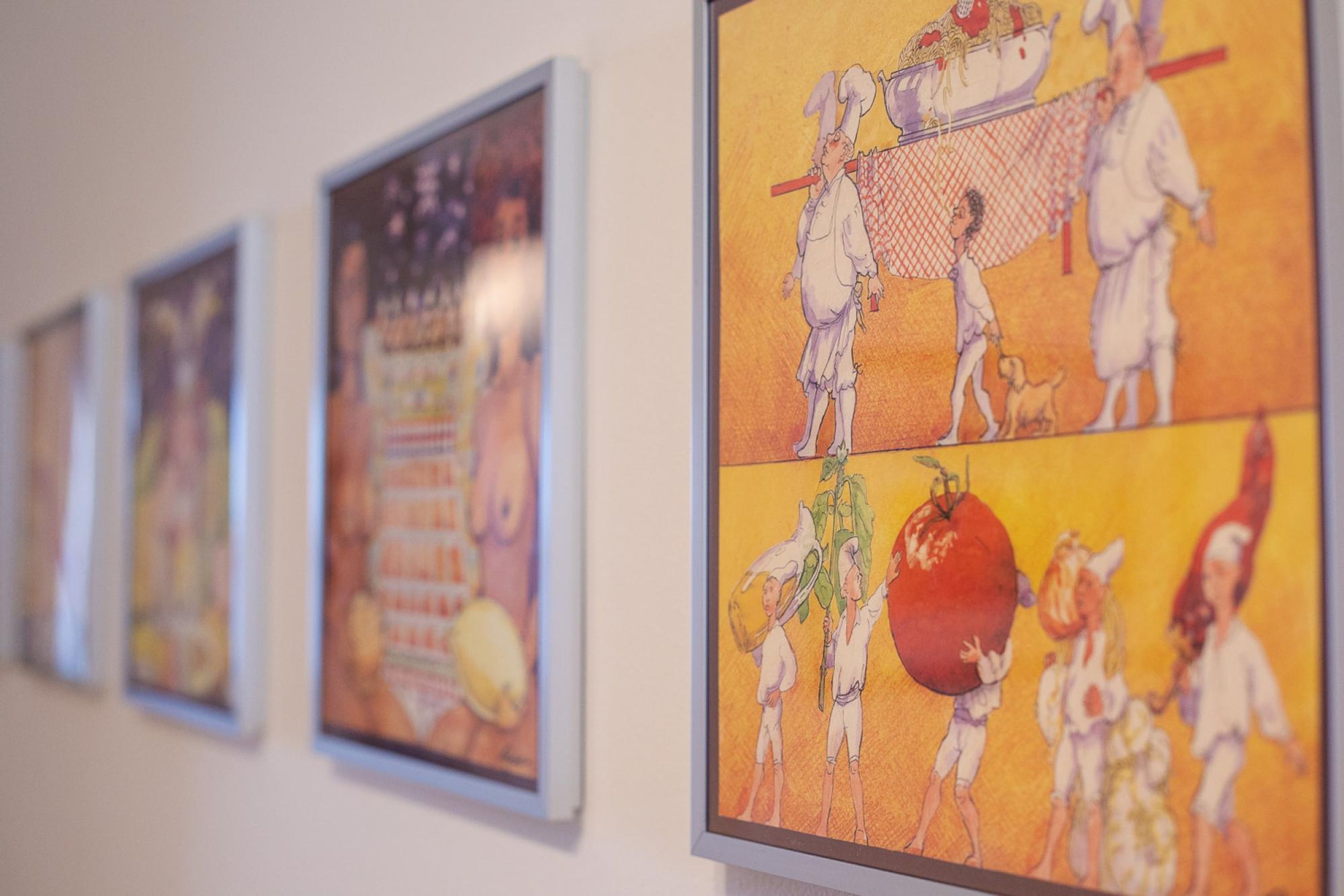 Une série d’œuvres d’art encadrées accrochées au mur.