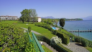 A hotel with a pool, a view of the lake, and a mountain in the background. - San Sivino 55 con Piscina by Wonderful Italy (Manerba del Garda)