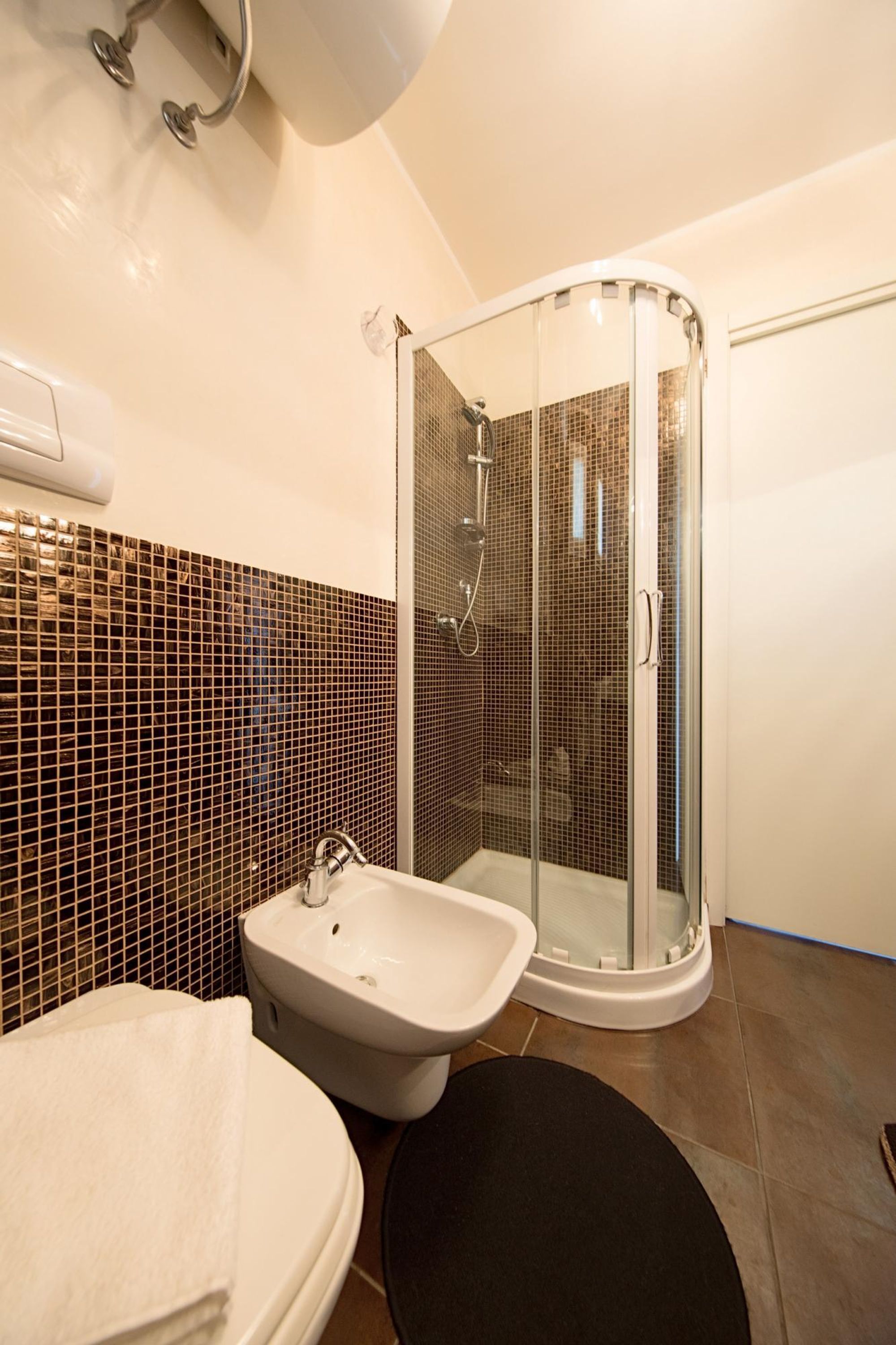 Un bagno moderno con doccia vetrata, lavandino bianco e bidet.
