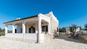 A white building with a stone facade, a covered patio, and a stone courtyard. - Villa Tranquillo 1876 by Wonderful Italy (Ostuni)
