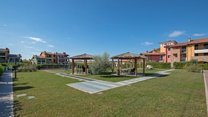 A courtyard with two gazebos, a paved walkway, and a grassy area. - Baglio Degli Ulivi 3 by Wonderful Italy (Sirmione)