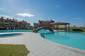 A swimming pool with a bridge, tiled deck, and a gazebo. - Baglio Degli Ulivi 3 by Wonderful Italy (Sirmione)