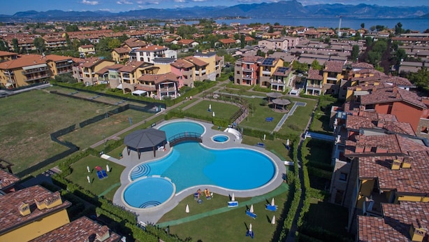 A resort with a large central pool, multiple smaller pools, and a well-maintained lawn area. - Baglio Degli Ulivi 3 by Wonderful Italy (Sirmione)