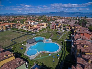 A resort with a large central pool, multiple smaller pools, and a well-maintained lawn area. - Baglio Degli Ulivi 3 by Wonderful Italy (Sirmione)