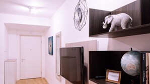 A modern interior with a flat-screen TV, a globe, and a framed certificate on a shelf. - Design Apartment Alle due Torri by Wonderful Italy (Bologna)