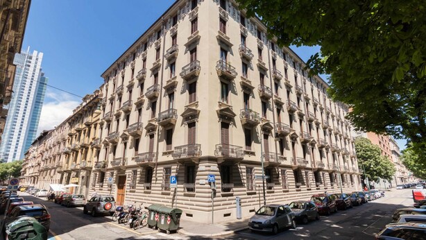 Um edifício de vários andares com estilo arquitetônico clássico, com varandas e fachada uniforme.