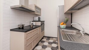Uma cozinha compacta com micro-ondas, fogão e pia.