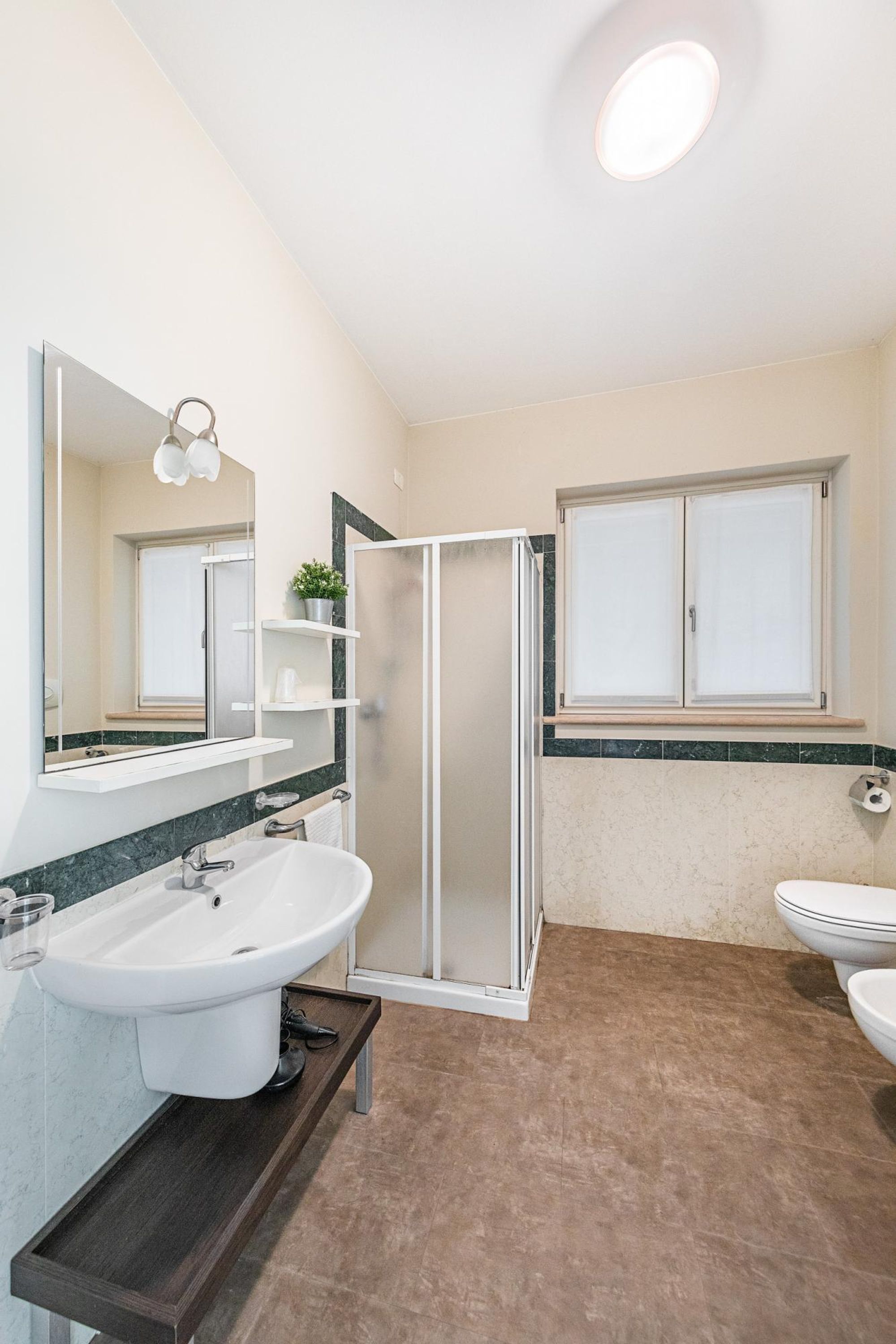 Un bagno con doccia, lavandino e water.