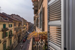 A narrow street lined with multi-story buildings, some with balconies and flower boxes. - S Salvario Family Apartment by Wonderful Italy (Turin)