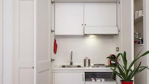 A compact kitchenette with a sink, a small countertop, and cabinets. - Elegant Studio in the City Center by Wonderful Italy (Genoa)