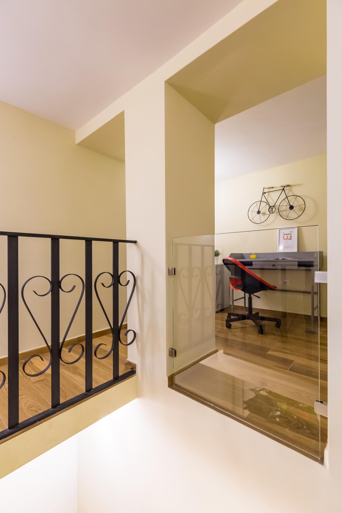 A modern office space with a desk, chair, and a bicycle decoration on the wall.