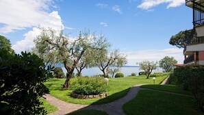 A pathway leading to a building with a view of a lake. - San Sivino 42 con Piscina by Wonderful Italy (Manerba del Garda)