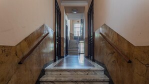 Eine Marmortreppe mit schwarzen Geländern, die zu einer Aussichtsplattform führt.