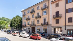 A multi-story building with balconies, parked cars, and a clear sky. - Ai Piedi Della Collina by Wonderful Italy (Turin)