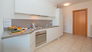 A modern kitchen with white cabinets, a stainless steel stove, and a tiled floor. - Benacus E4 Apartment by Wonderful Italy (Sirmione)