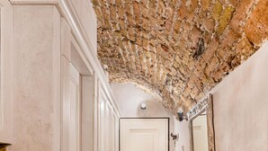 A narrow hallway with a brick ceiling, white doors, and a tiled floor. - C era una Volta in Centro by Wonderful Italy (Desenzano del Garda)