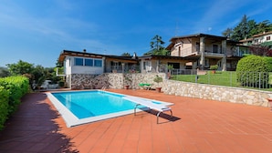 A modern villa with a swimming pool, stone walls, and a well-maintained garden. - Casa Alba con Giardino e Patio by Wonderful Italy (Lonato del Garda)