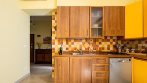 A compact kitchen with wooden cabinets, a stainless steel dishwasher, and a checkered backsplash.