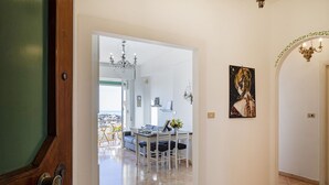 Un intérieur moderne avec un coin repas, un lustre et un tableau au mur.