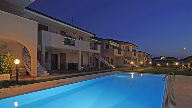 A swimming pool area with a modern building in the background.