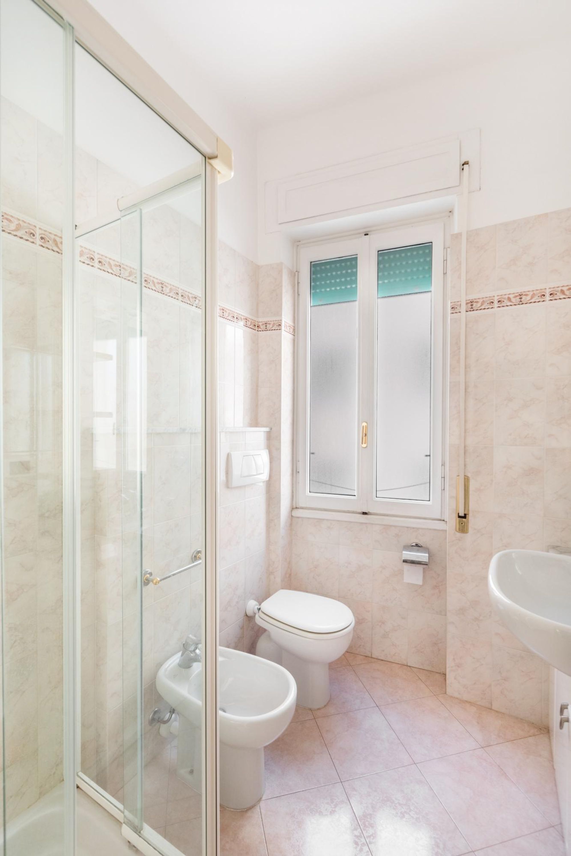 Une salle de bain avec une douche à parois de verre, des toilettes et un lavabo.