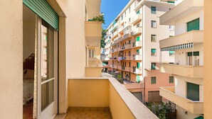 A narrow balcony with a view of adjacent multi-story buildings, featuring balconies with plants and laundry. - I Fiori 3 16 Apartment by Wonderful Italy (Sanremo)