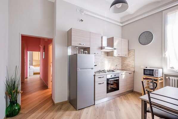 Eine moderne Küche mit Kühlschrank, Backofen, Mikrowelle und Holzschränken.