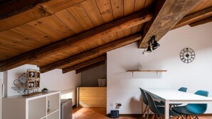 A dining area with a wooden ceiling, a white table, and blue chairs.