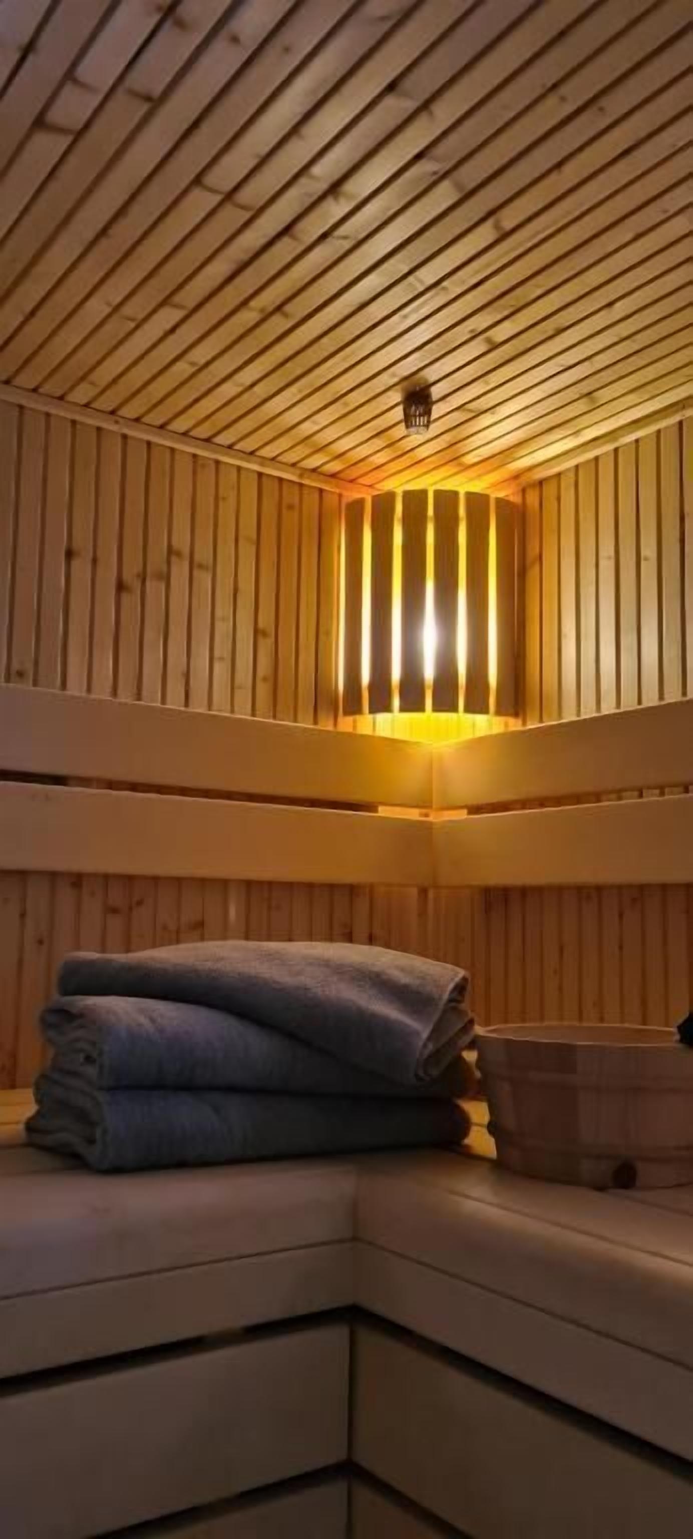 L'intérieur d'une cabane en bois, avec un lit superposé et un petit coin salon.