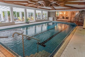 Una piscina cubierta, una piscina al aire libre de temporada, tumbonas