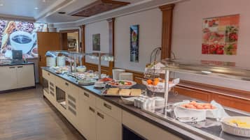 Disposição de buffet com diversos alimentos e um canto de café.
