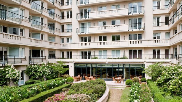 A multi-story residential building with balconies, a central courtyard with seating, and well-maintained gardens. - Paris15 Balcony Parking, 1bedroom, sleeps 4 (Issy-les-Moulineaux)