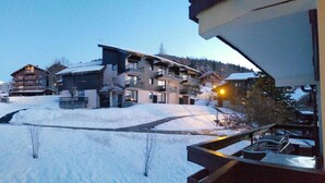 Uma área externa coberta de neve, com edifícios ao fundo.