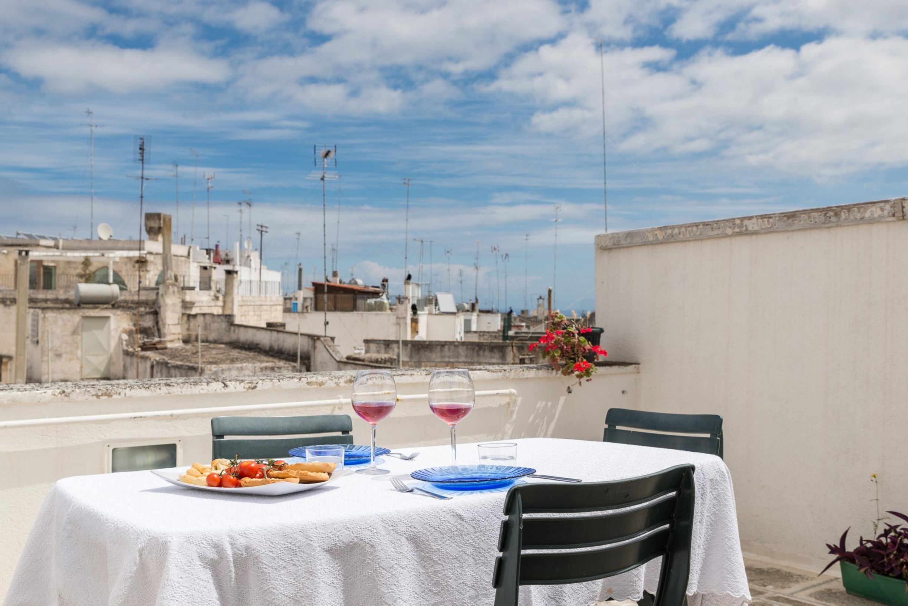 Una tavola imbandita per due con vista sugli edifici sullo sfondo.