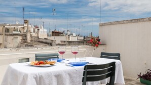 A table set for two with a view of buildings in the background. - Terrazza Primavera by Wonderful Italy (Ostuni)