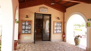 A stone-floored entrance with a sign reading "Lounge Internet Point Biblioteca".