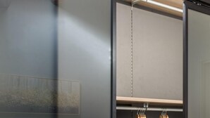 A modern bedroom with a large bed, a wardrobe with a sliding door, and a hanging clothes rack. - Casa con Giardino all ex Fabbrica di Pomodoro by Wonderful Italy (Palermo)