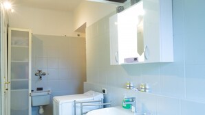 A bathroom with a white sink, a mirror, and a toilet. - Casa Garisenda by Wonderful Italy (Bologna)