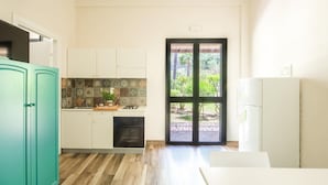 A modern kitchen with white cabinets, a teal-colored fridge, and a tiled backsplash. - L Ulivo Blu - One-bedroom With Garden by Wonderful Italy (Castellammare del Golfo)