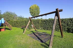 Ein Spielplatz mit Schaukel und Rutsche.