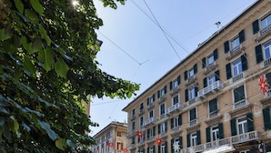 Un edificio a più piani con balconi e finestre, immerso nel verde.