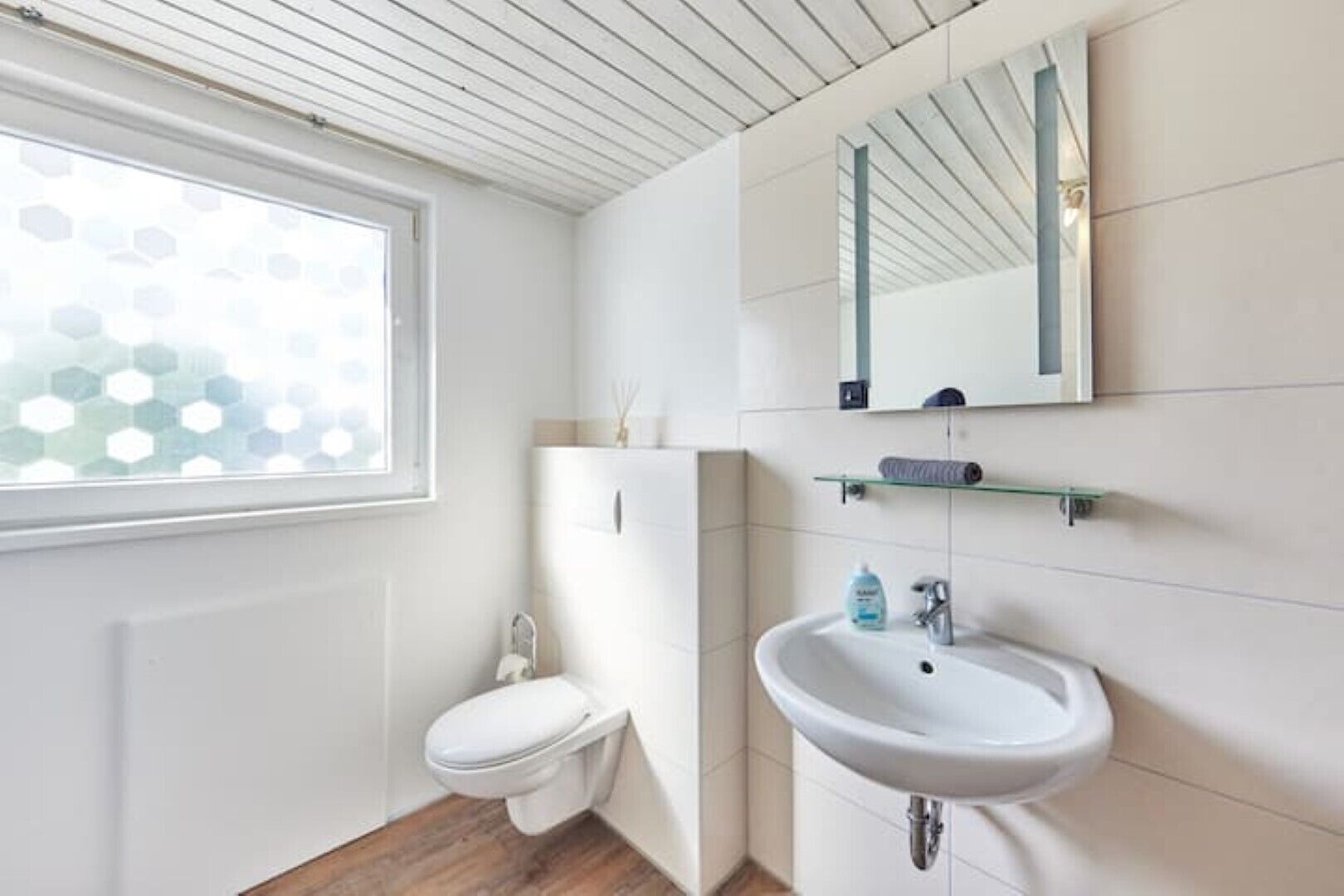 Un baño con inodoro, lavabo y ventana.