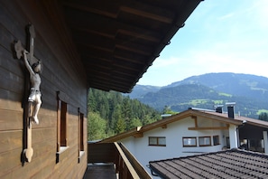 Un edificio de madera con un balcón que da a un paisaje montañoso.