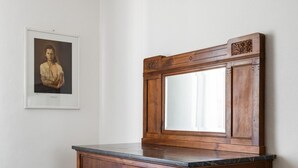 A wooden cabinet with a marble top and a mirror.
