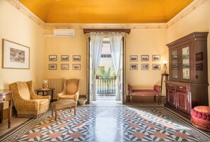 A room with patterned floor tiles, a wooden cabinet, and two armchairs. - Casa Ugdulena con Piscina by Wonderful Italy (Palermo)